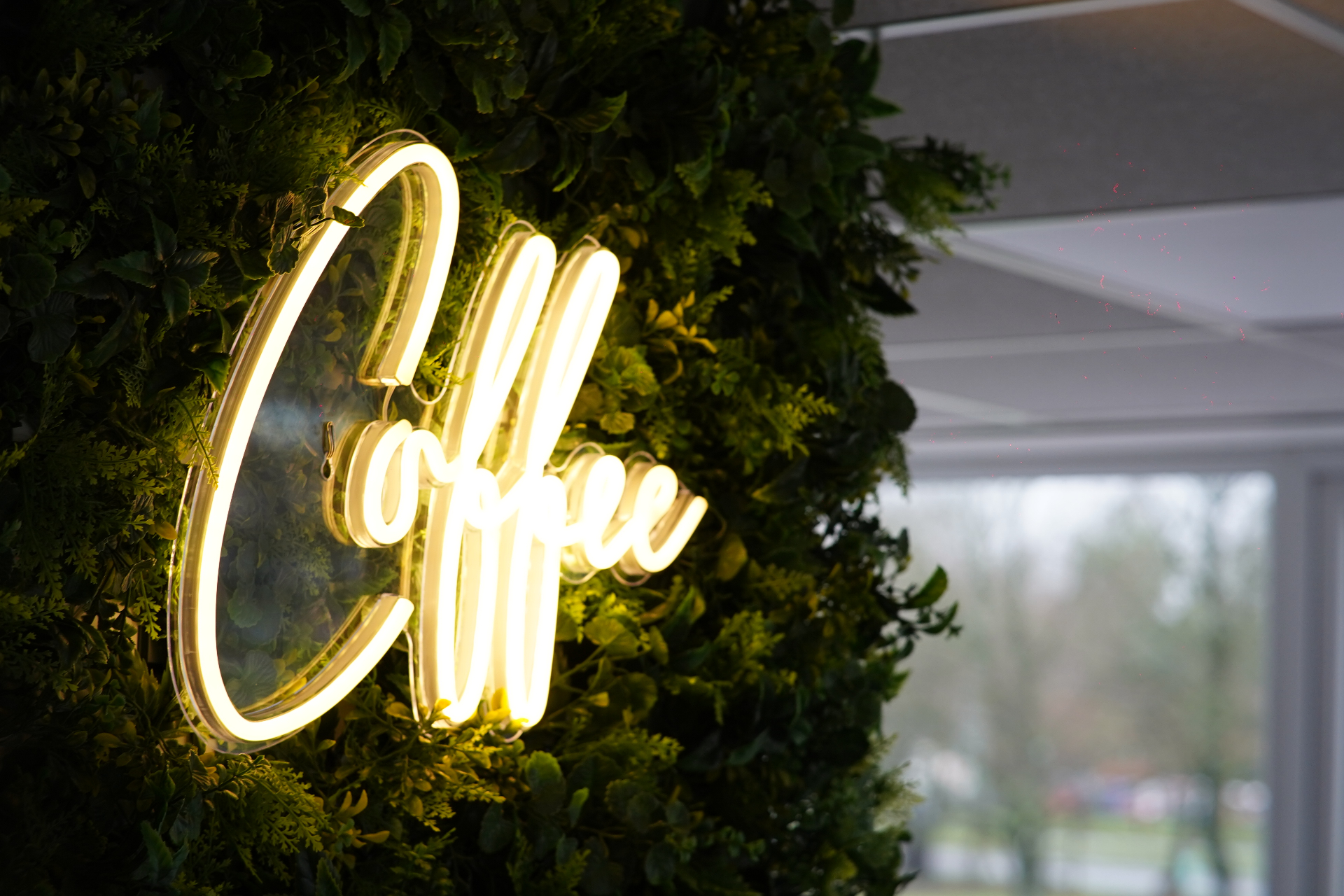 Warm coworking space at Burbspace with a glowing red coffee neon sign